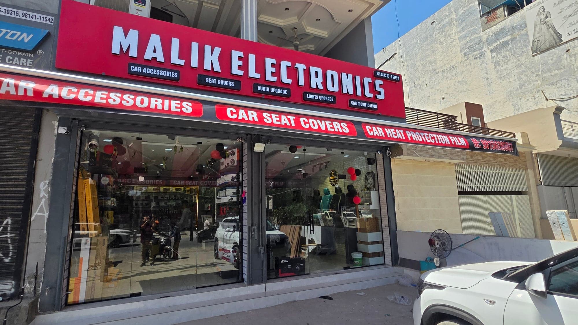 Angled view of the Malik Electronics storefront and glass frontage, Dugri, Ludhiana
