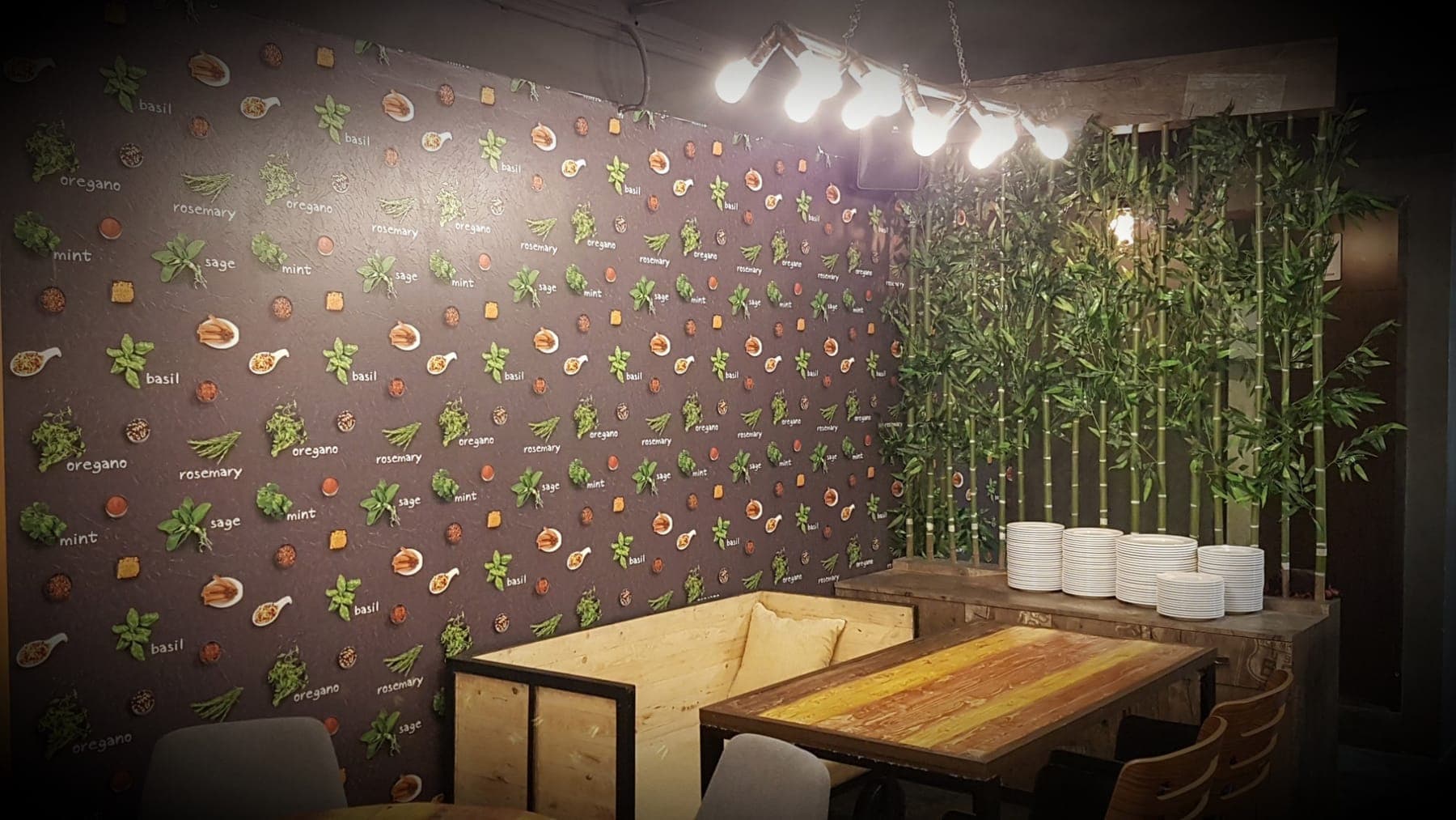 Herb-themed wall covering with a bamboo partition and a wooden lounge booth, FiTreat restaurant, Ludhiana
