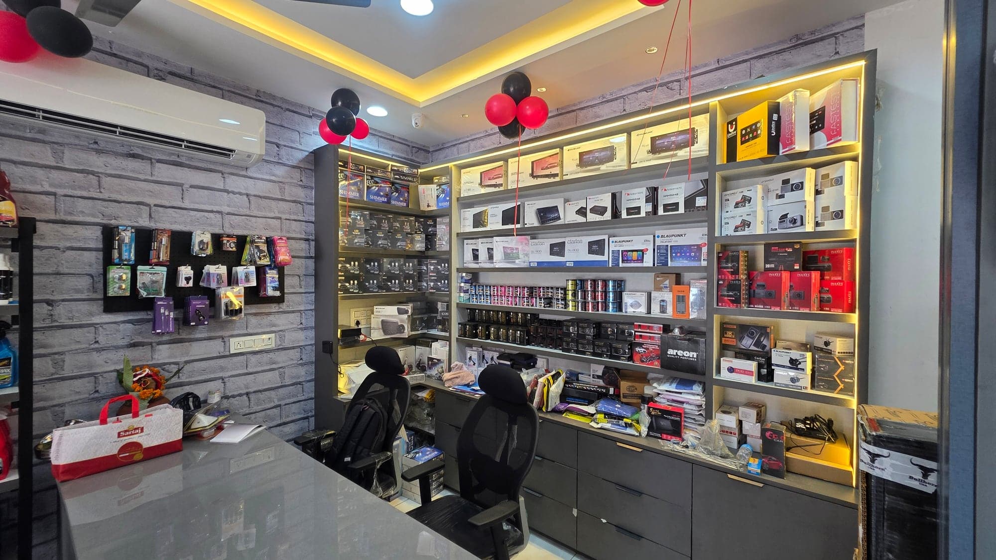 Billing counter and backlit product shelving in the Malik Electronics car accessories showroom, Dugri, Ludhiana