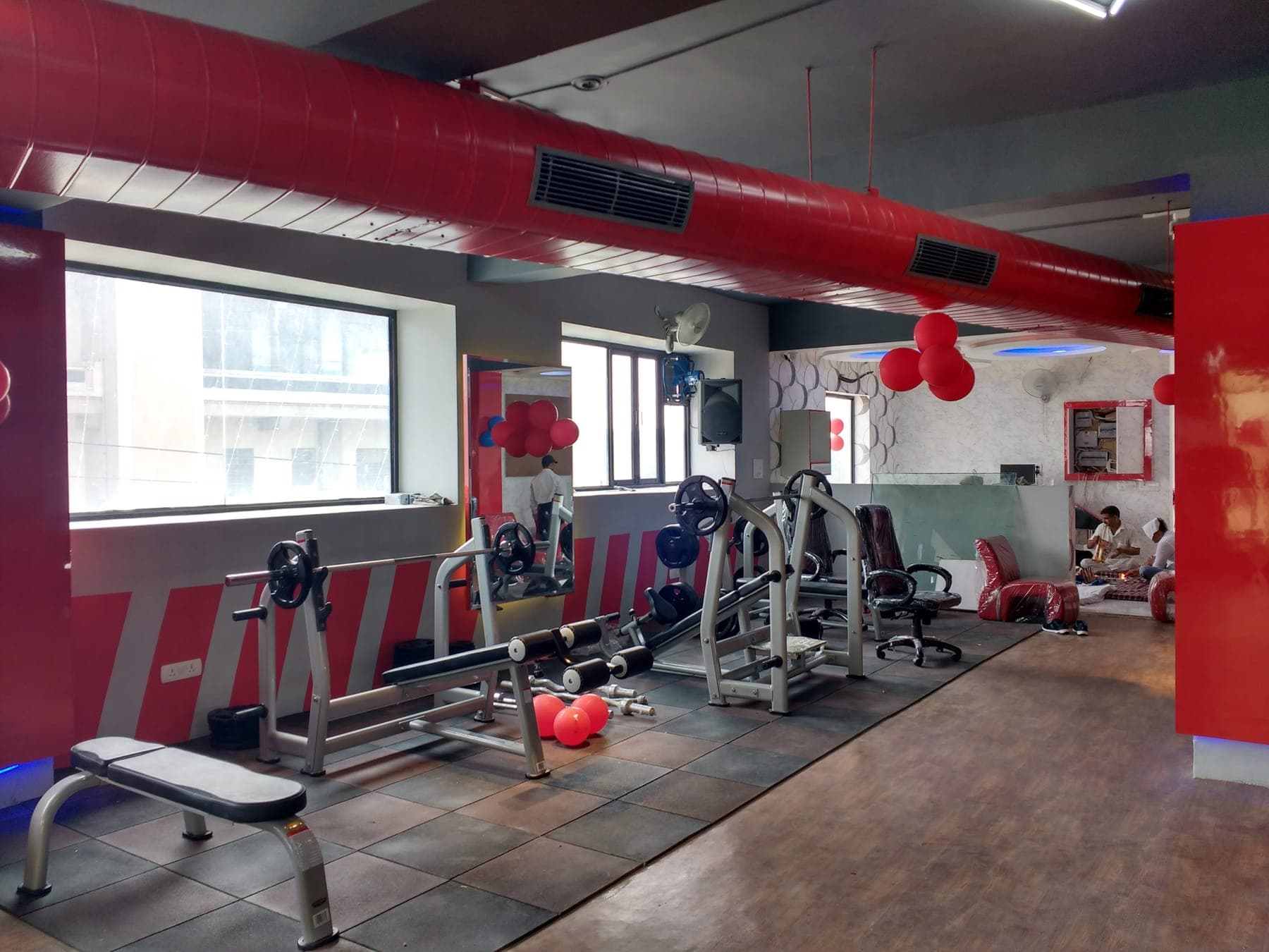 Open floor plan with wood-finish flooring, red duct and linear light fixture, Quillian Gymnasium, Ludhiana